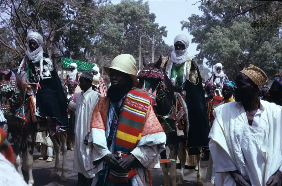 Colour photograph of horsemen in bright robes at the FESTAC ’77 Grand Durbar, a crowd behind them.