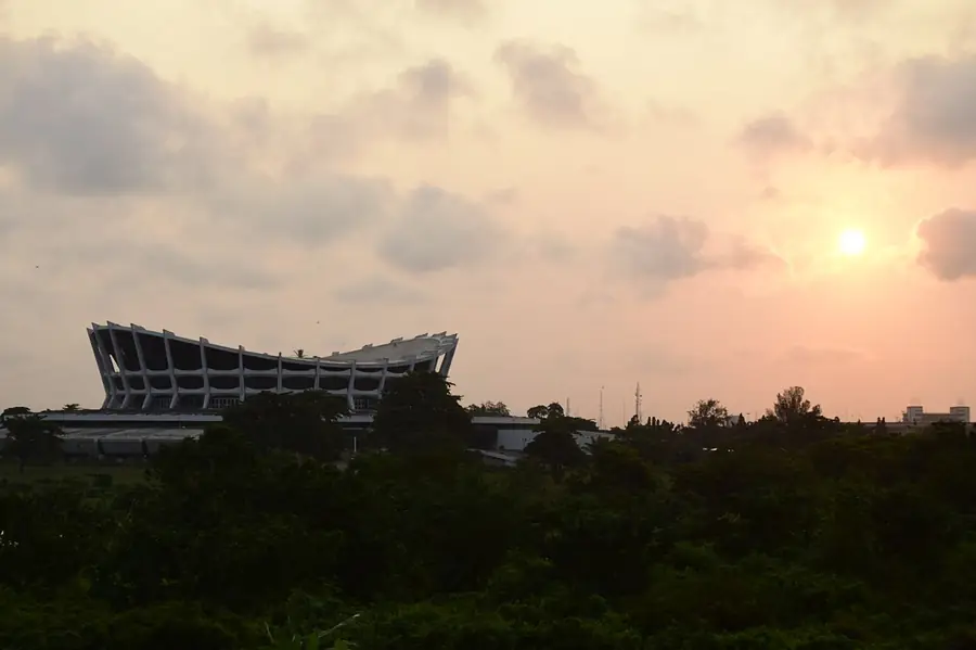 The National Theatre in Iganmu, Lagos: a ring-shaped building with a ridged roof, seen across a road.
