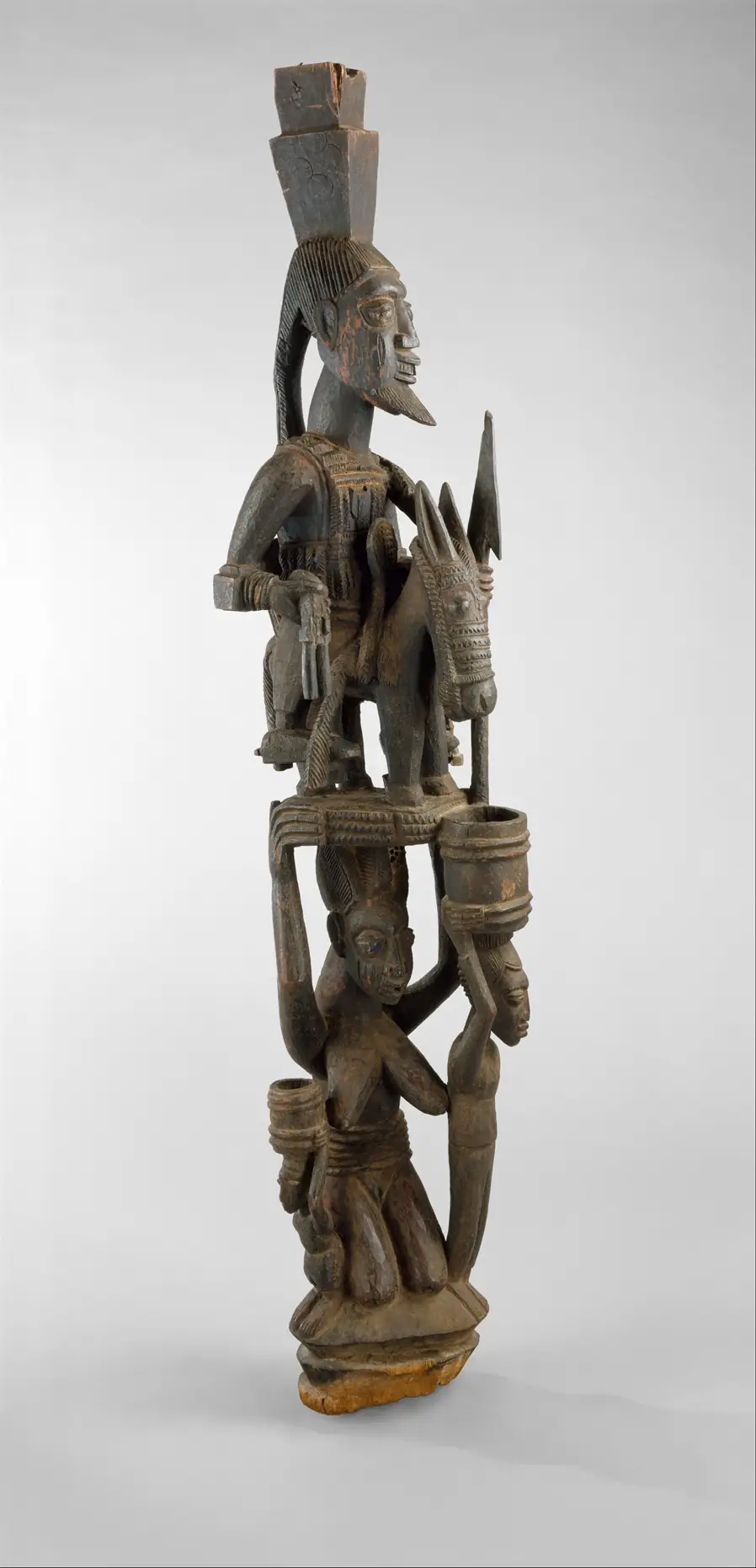 A carved wooden veranda post by Olowe of Ise: a rider on horseback above a standing woman.